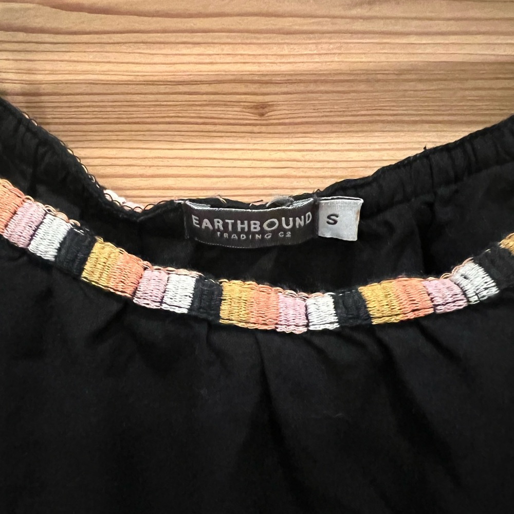 Off the shoulder breezy top with colorful embroidered detailing.